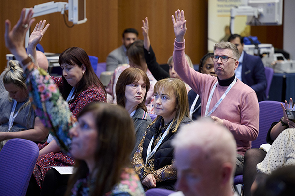 Members at conference with raised hands